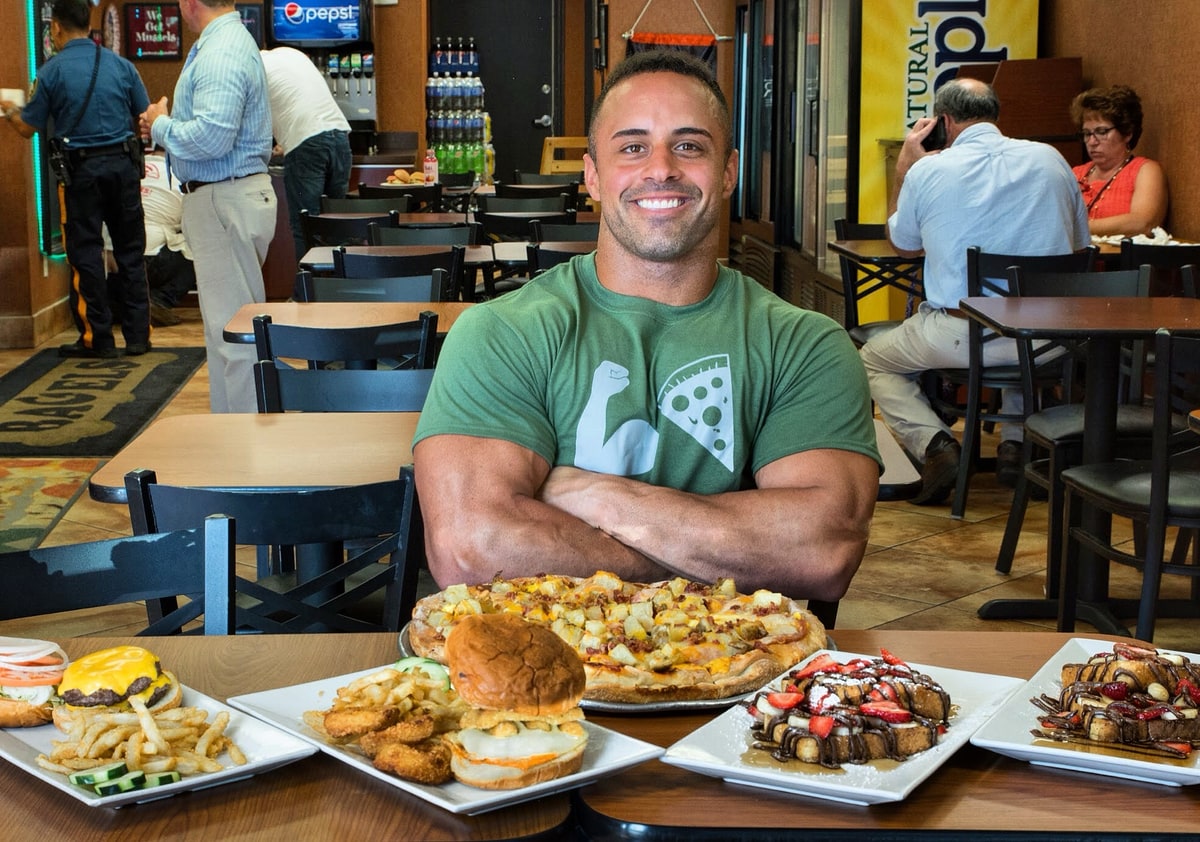 Pietro Mazzella seated at Brother Bruno with a spread of pizza and food