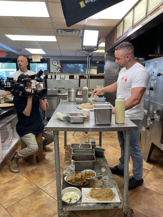 A camera operator films Pietro preparing dessert pizza