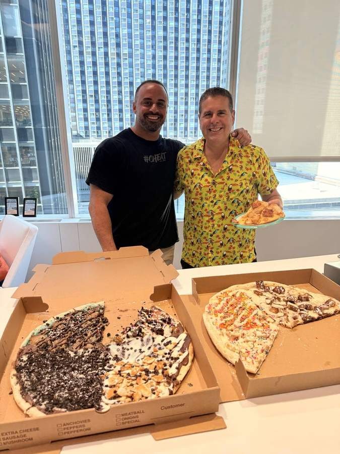 Pietro carrying two boxes of dessert pizza at a Manhattan studio